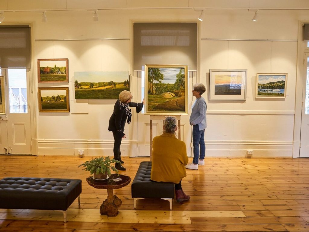 Visitors looking at landscape paintings in the Raillery Hub gallery